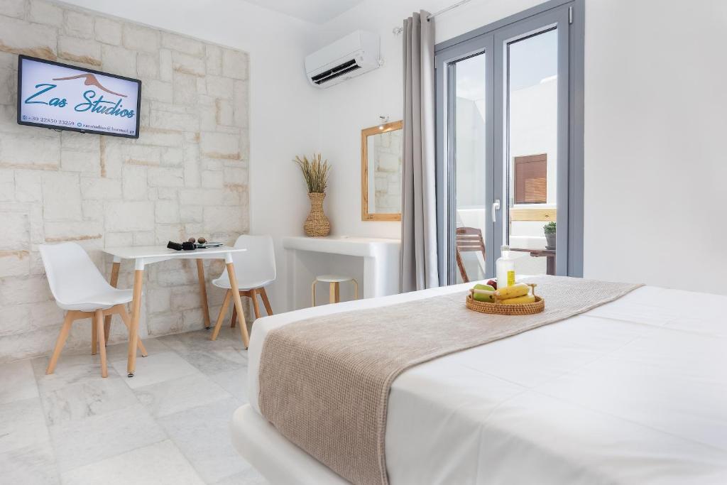 una camera con letto, tavolo e sedie di Zas Studios a Naxos Chora