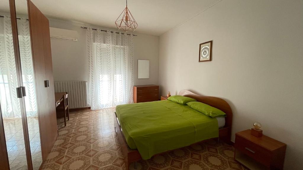 1 dormitorio con 1 cama con manta verde en La Finestra sul Borgo en Campomarino