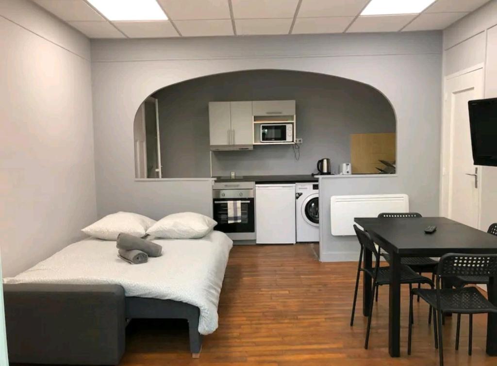 Cette chambre comprend un lit, une table et une cuisine. dans l'établissement Charmant Studio-Lyon 3éme, à Lyon