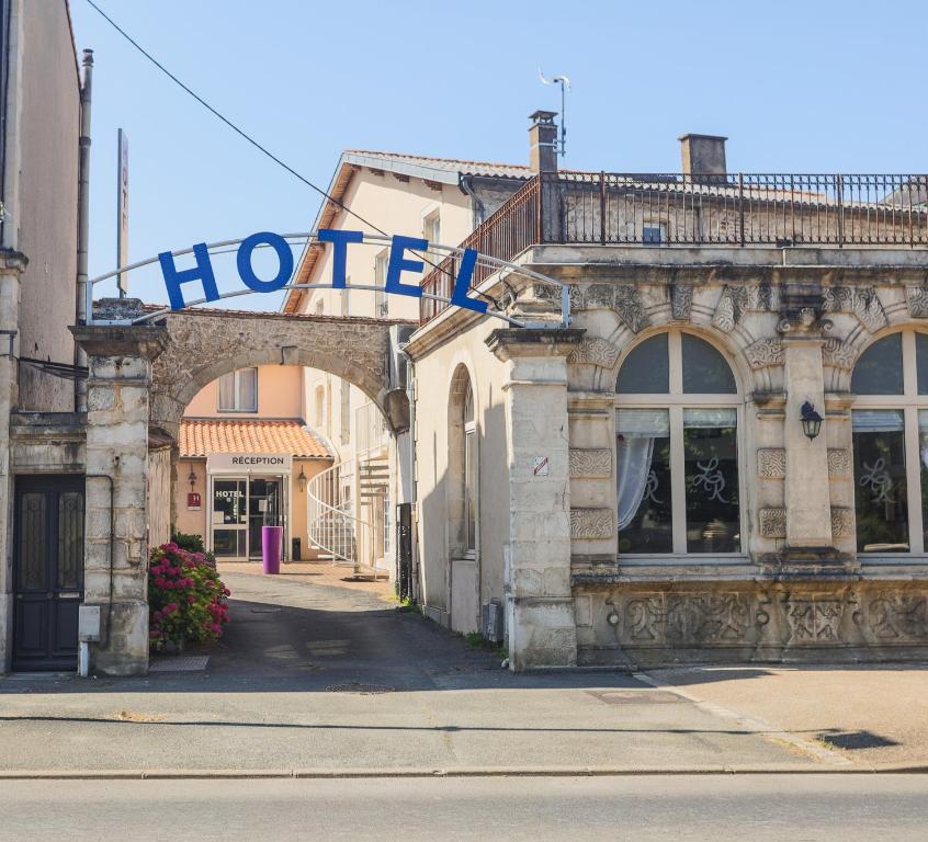 un vieux bâtiment avec un panneau d'hôtel dans une rue dans l'établissement Hôtel Le Cheval Blanc, à Saint-Maixent-lʼÉcole