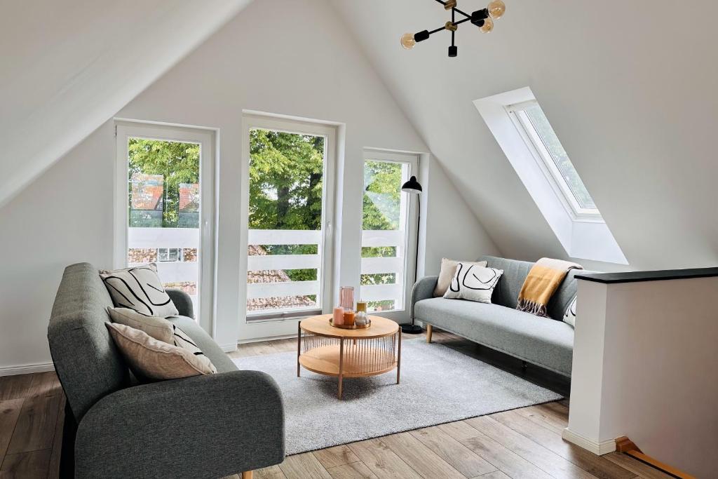 a living room with two couches and a table at Der Stader Hafenblick in Stade