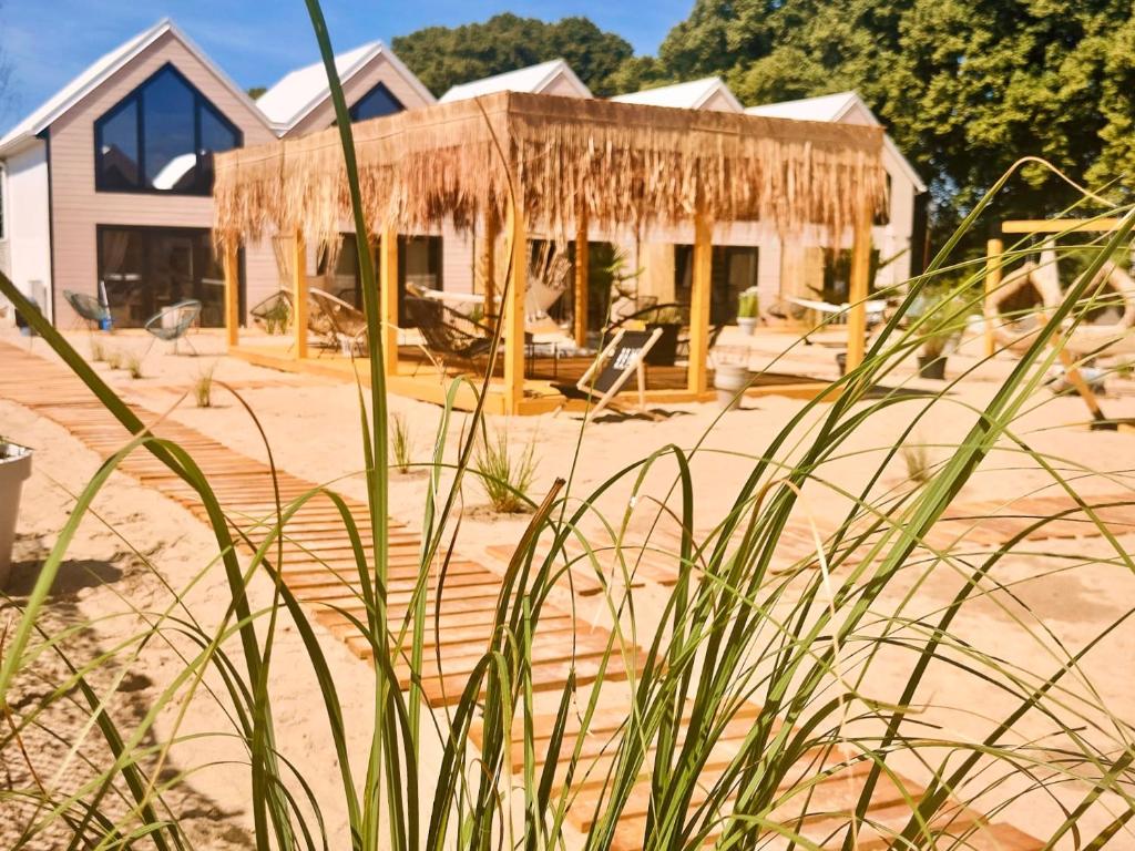 dom na plaży ze słomianym dachem w obiekcie Lulu Holiday Resort w mieście Mielno