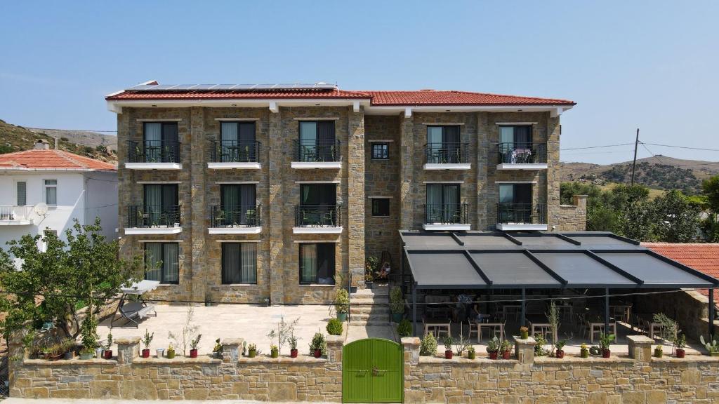 a large brick building with a black roof at Maslin Butik Otel in Gokceada Town