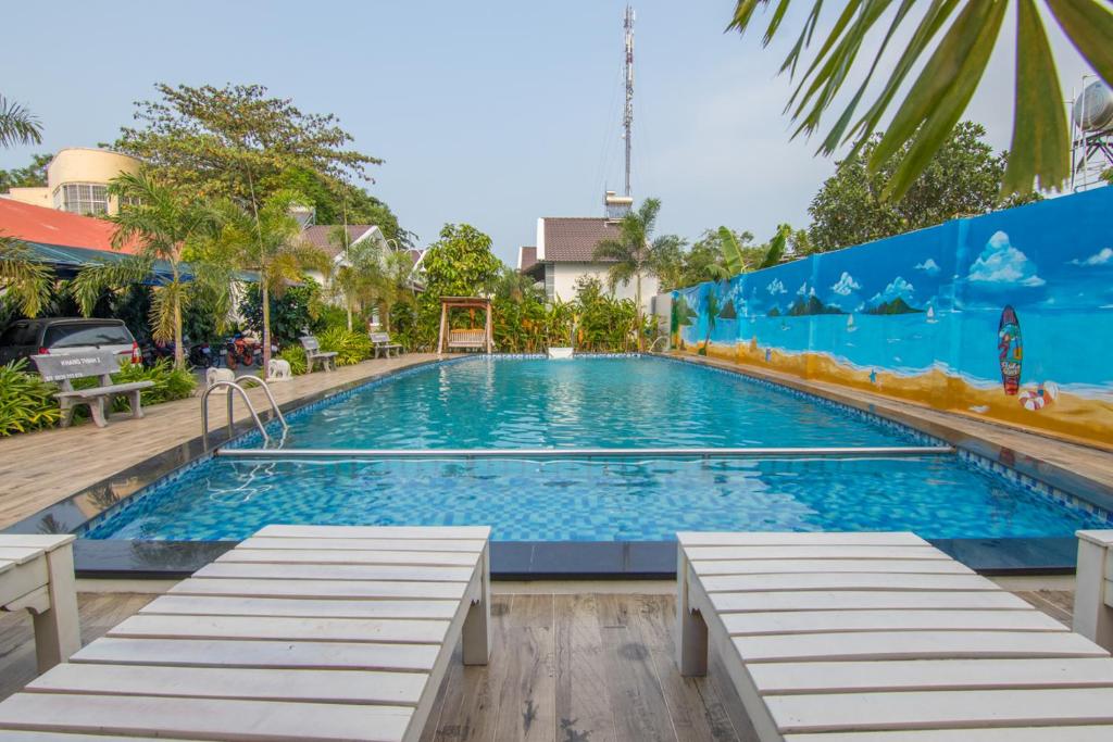 una gran piscina con bancos frente a un edificio en Tây Tiến Bungalow, en Phu Quoc