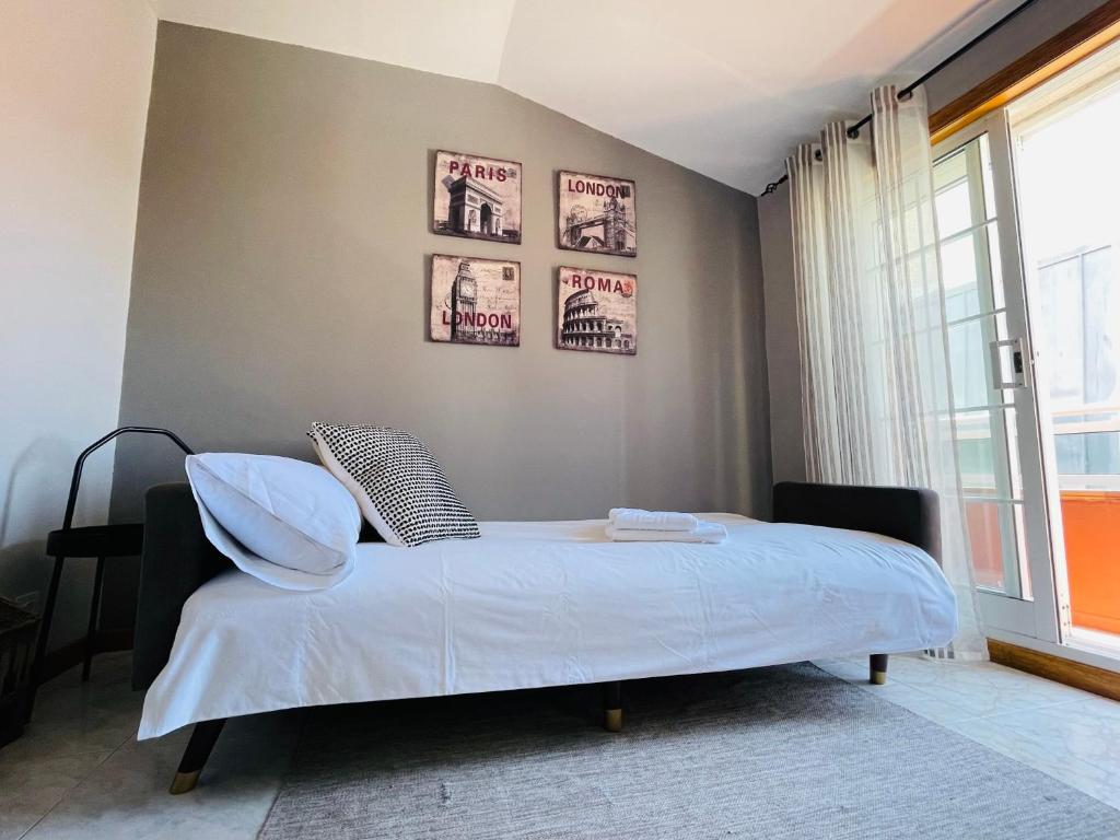 a bedroom with a bed with two posters on the wall at El Apartamento de la Colegiata in Vigo