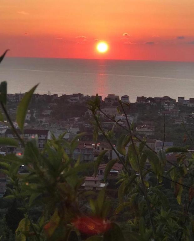 a sunset over the ocean and a city at Dal barone in Capo dʼOrlando