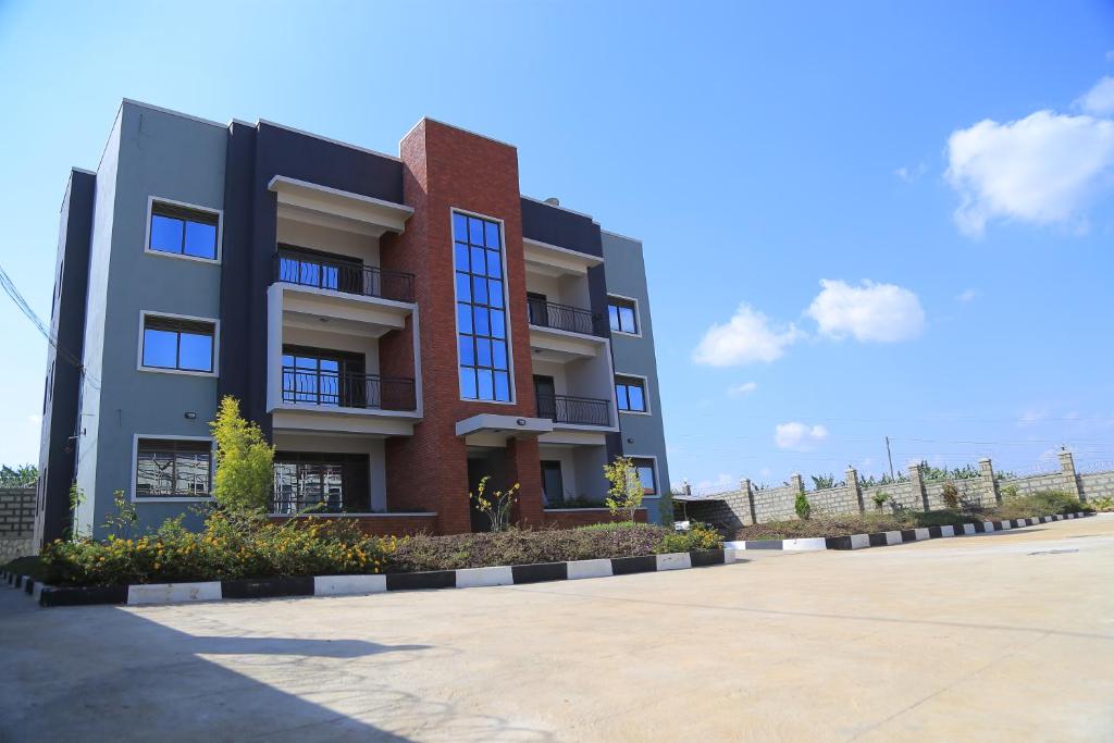 a apartment building with a parking lot in front of it at The Junction Apartments in Mbarara