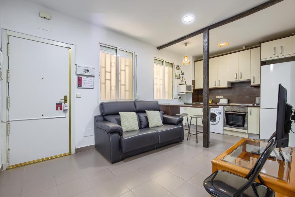 ein Wohnzimmer mit einem Sofa und einer Küche in der Unterkunft Charming Madrid Ferrocarril - Estancias Temporales in Madrid