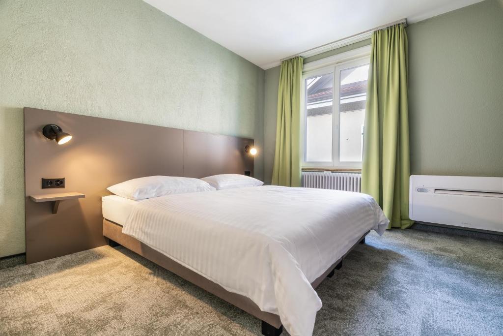 a bedroom with a large bed and a window at flexymotel Schönenwerd in Schönenwerd