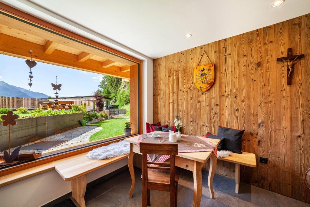 a dining room with a table and a window at Mühlanderhof Apt Klopairspitze in Resia