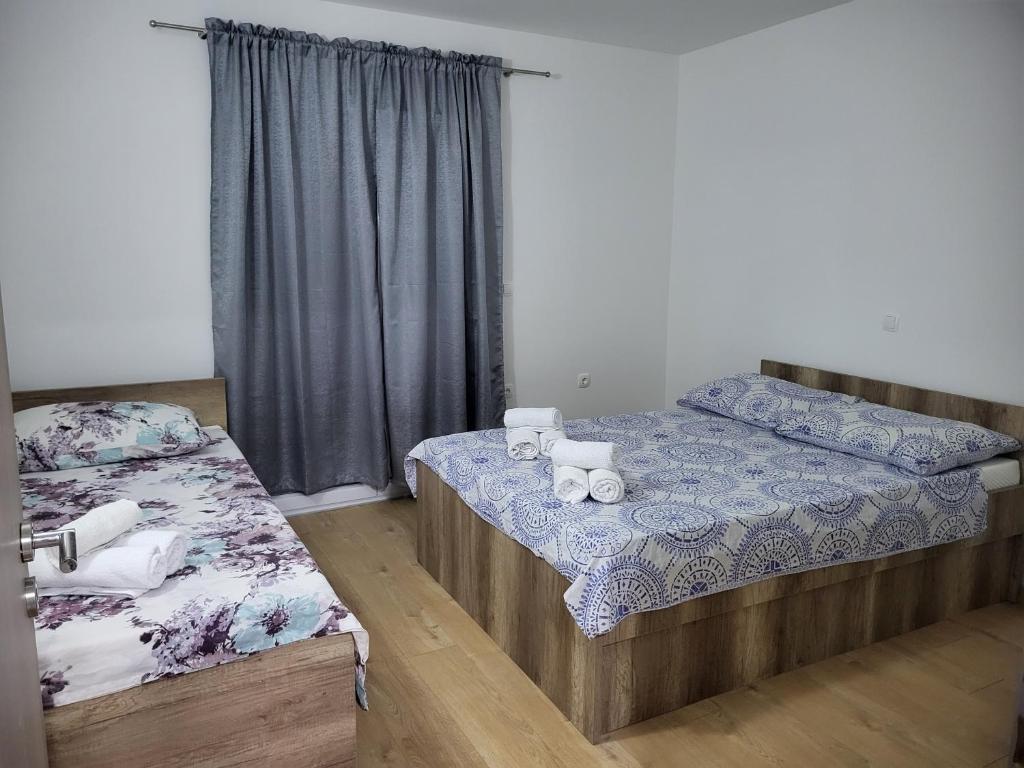 a bedroom with two beds and a window at Apartmani Škorpion in Kaštela