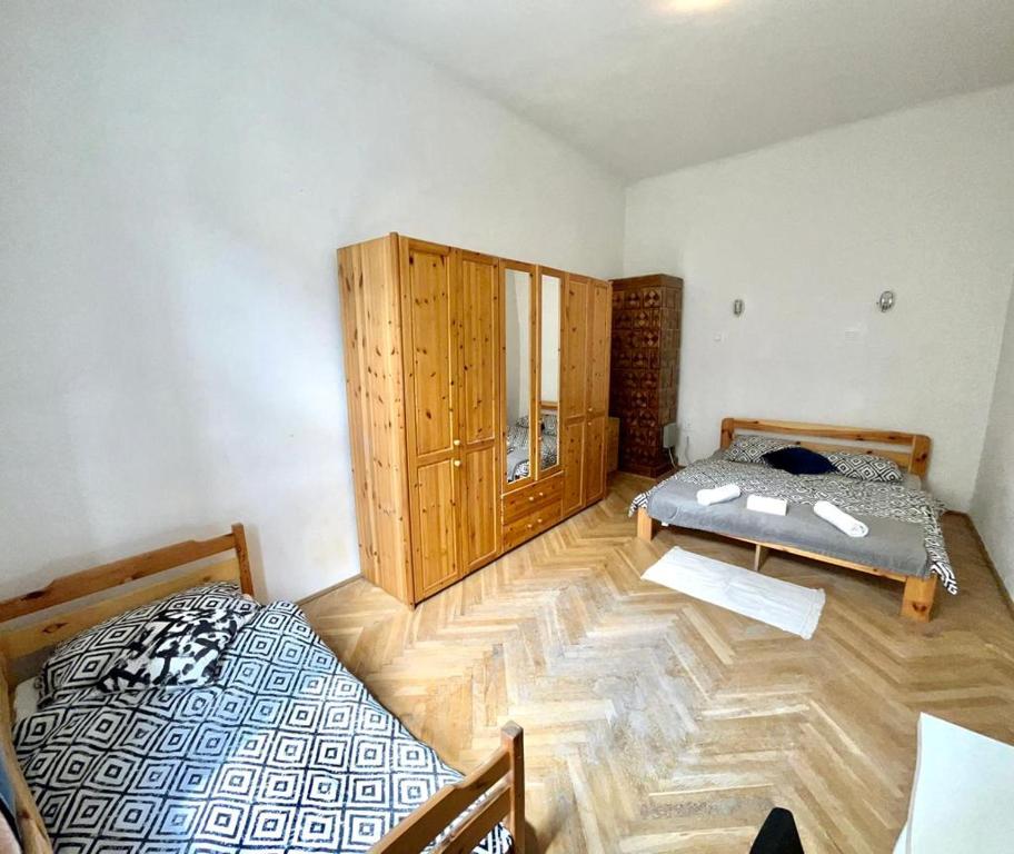 um quarto com 2 camas e piso em madeira em Nice bedroom near the bus and train station na Cracóvia