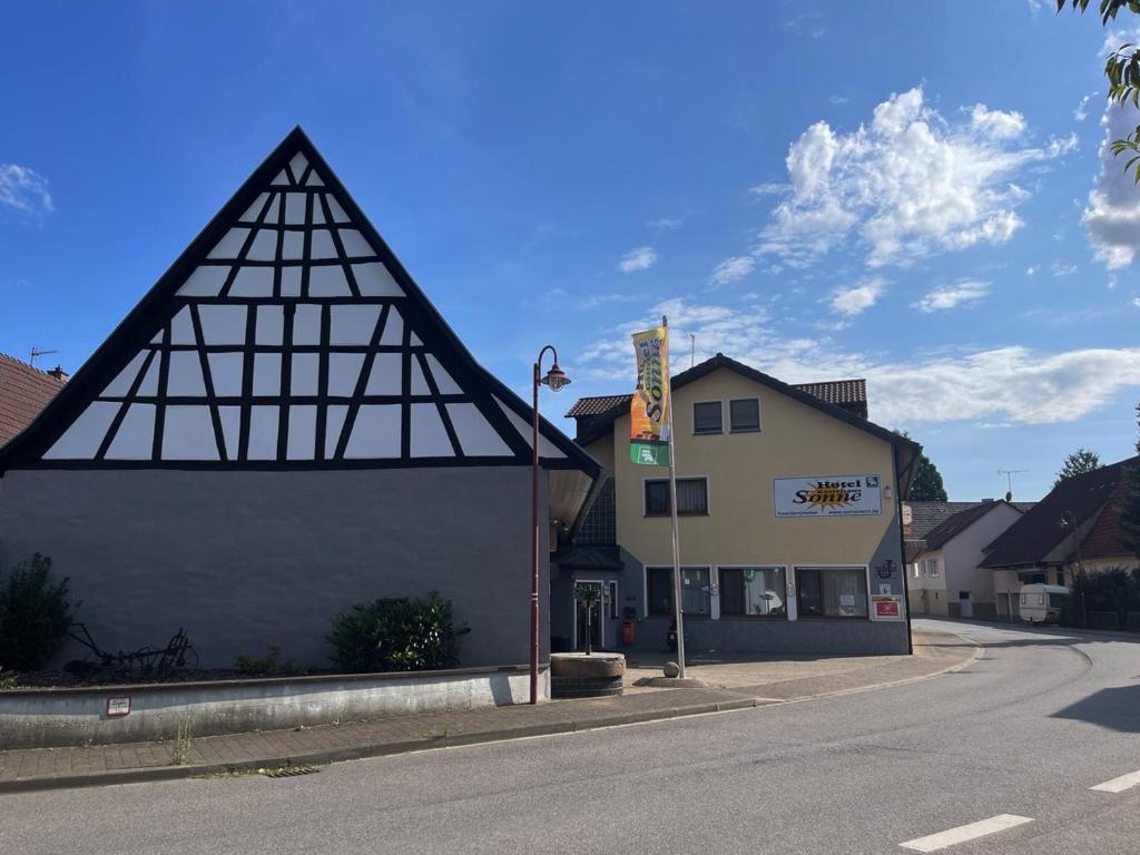 a building with a triangular roof on the side of a street at Hotel Gästehaus Sonne in Sinsheim