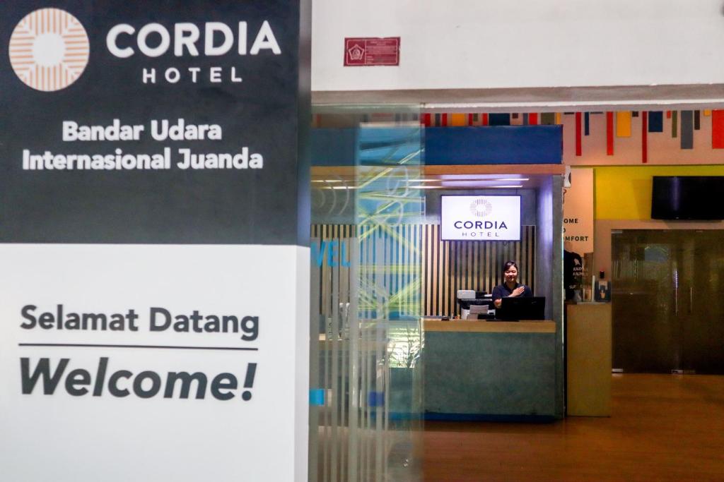 a woman sitting at a desk in an airport at Cordia Hotel Surabaya Airport - Hotel Dalam Bandara in Sidoarjo