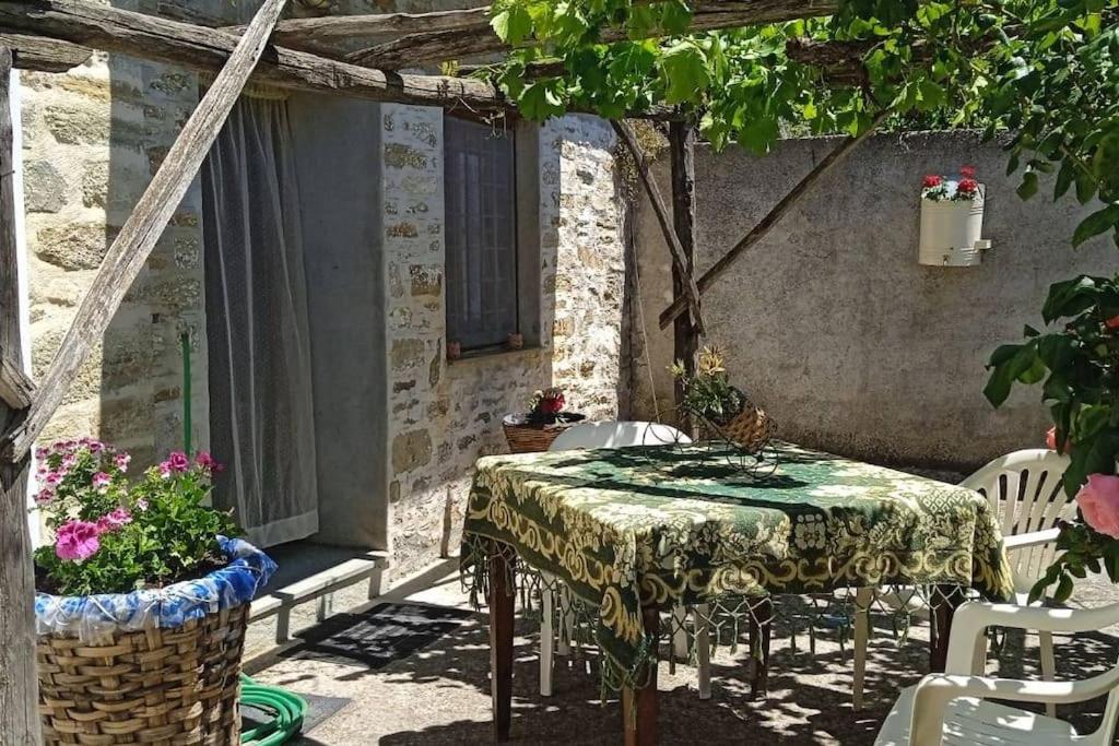 - une table et des chaises sur la terrasse couverte d'une maison dans l'établissement Αρχοντικό Θεανώ 1 Archontiko Theano 1, à Agios Lavrentios