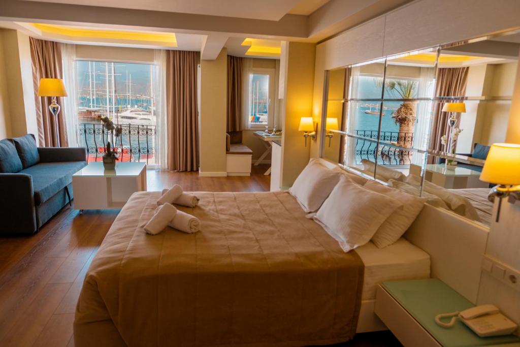 a hotel room with a large bed with a large window at Alesta Residence in Fethiye