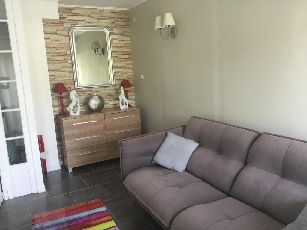 a living room with a couch and a mirror at Loft 1 in La Trinité