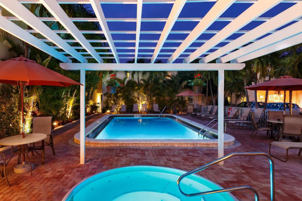 uma piscina com um tecto azul e uma mesa e cadeiras em Inn at the Beach-Venice FLORIDA em Venice