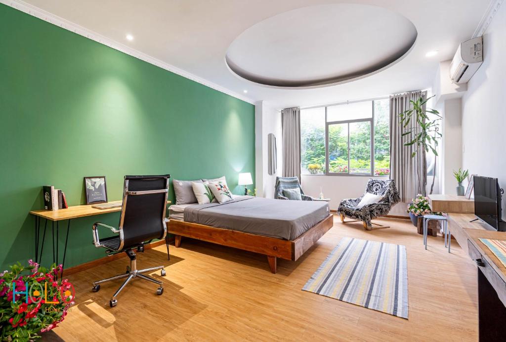 a bedroom with a bed and a green wall at HOLO BEN THANH SAIGON Serviced HomeStay in Ho Chi Minh City