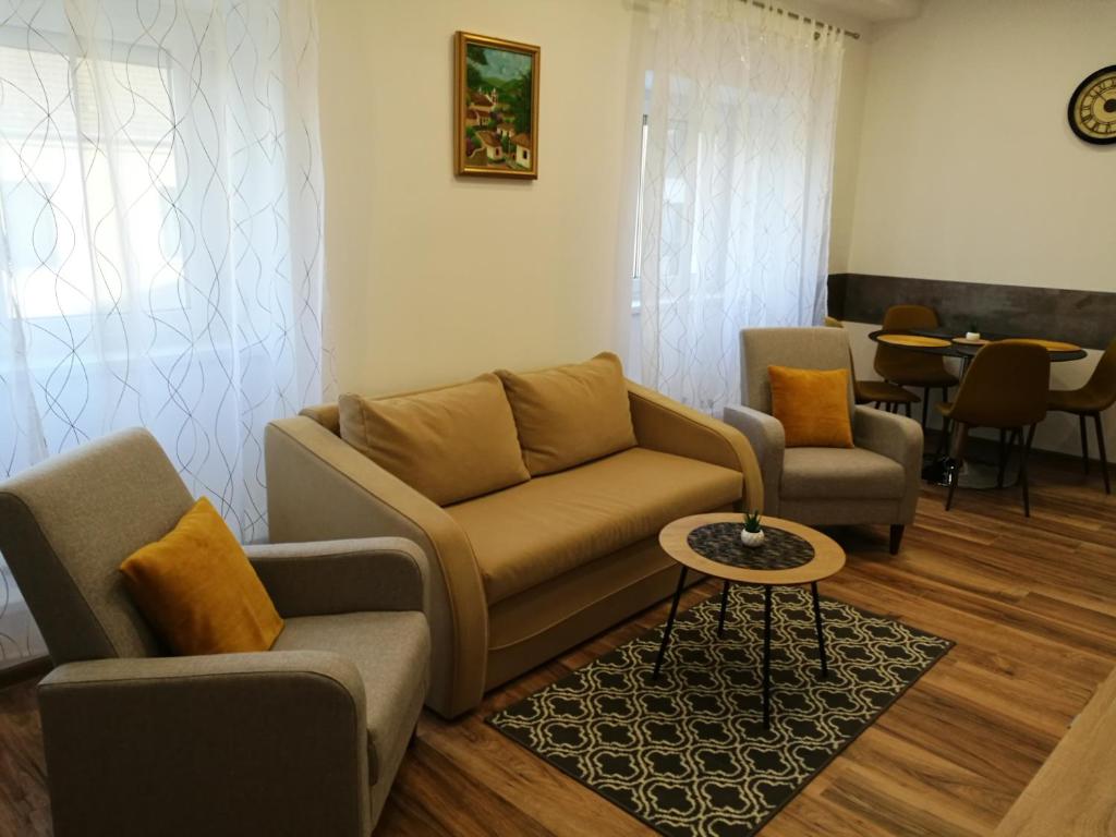 uma sala de estar com um sofá, cadeiras e uma mesa em Tower Apartman Kőszeg em Kőszeg