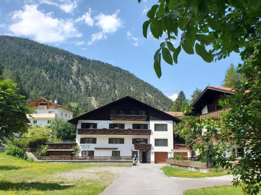 a large white building with a mountain in the background at Haus an der Sonne FeWo 2 in Biberwier