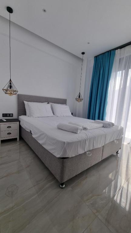 a bedroom with a large bed with blue curtains at Danielli Luxury Villas in Skala Rachoniou