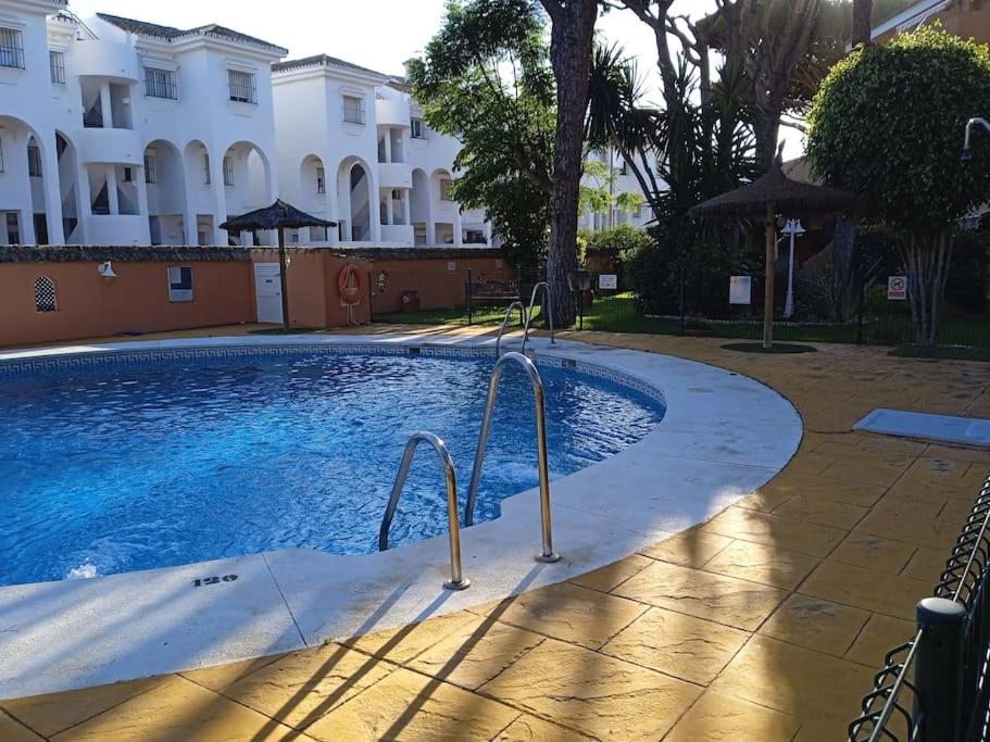 una piscina frente a un edificio en Apartamento La Caracola en Chiclana de la Frontera