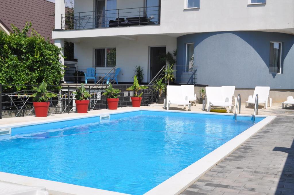 a swimming pool in front of a building at Vila Toscana in Eforie Nord