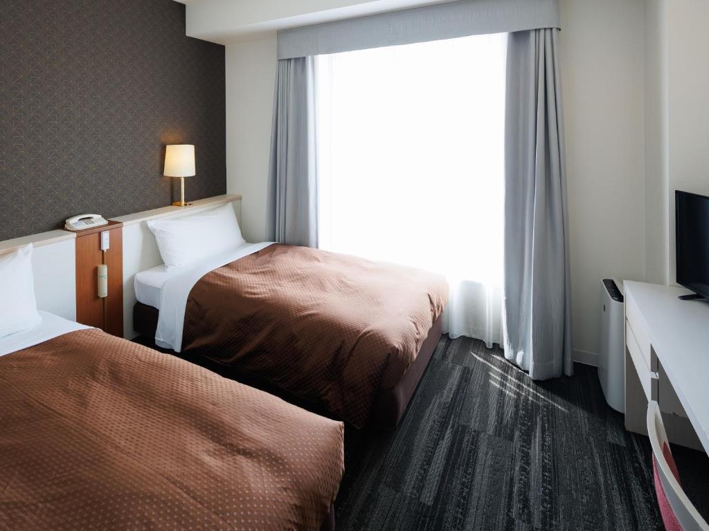 Postel nebo postele na pokoji v ubytování J Hotel Rinku