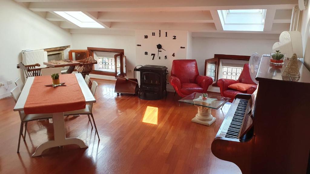 sala de estar con piano y muebles de color rojo en Flaminio's Suite Vittorio Veneto, en Vittorio Veneto