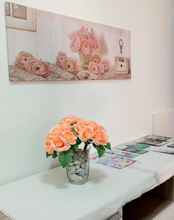 a vase filled with orange roses sitting on a table at Le Rose Apartment in Ortona