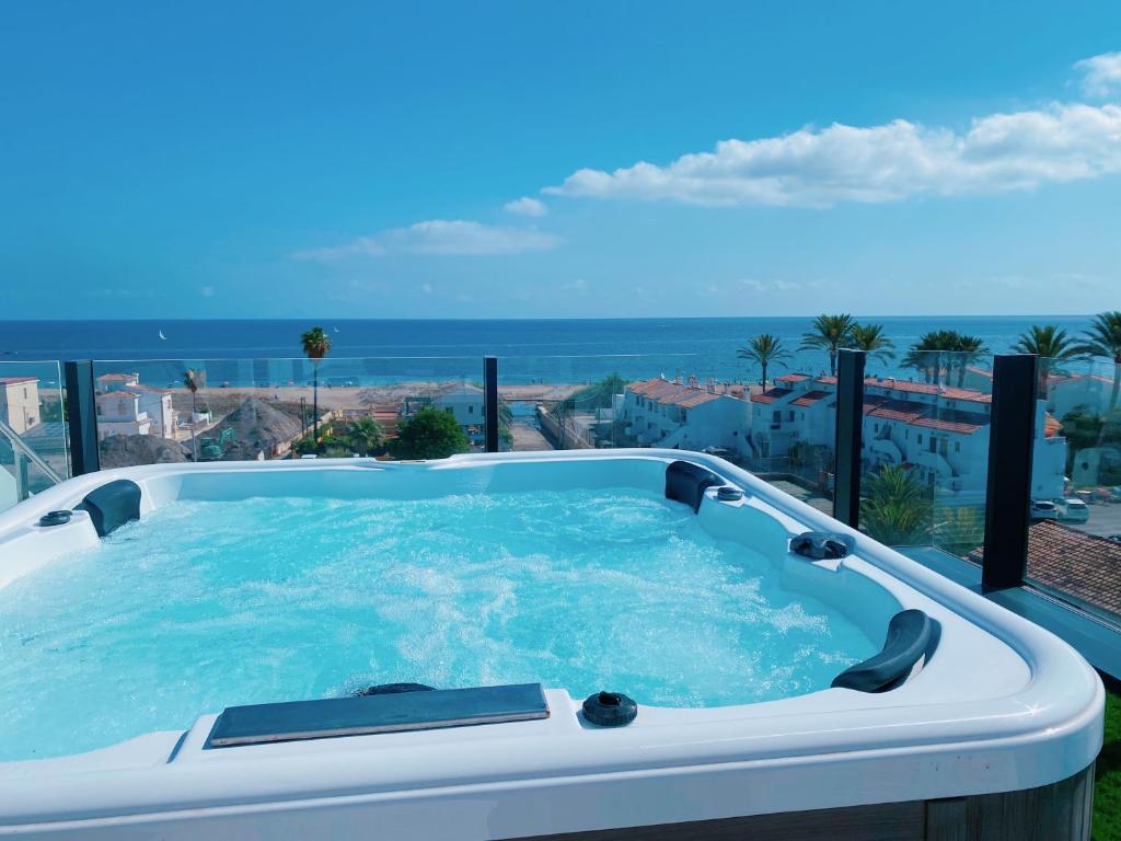 een hot tub op een balkon met uitzicht op de oceaan bij Apartamento exclusivo en la playa in Denia