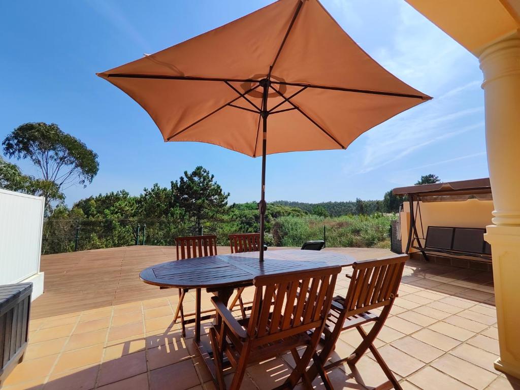 a table with an umbrella on a patio at Vila Limoeiro in Salir de Porto