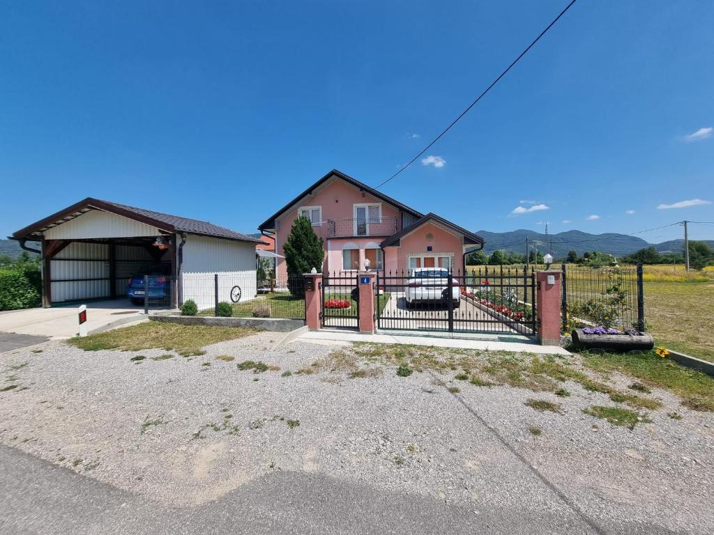 a house with a gate in front of a driveway at Zlata Apartment in Fužine