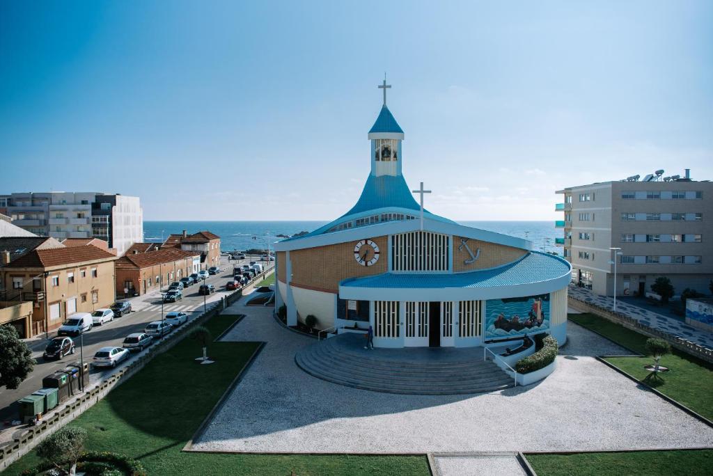 una iglesia con techo azul en una ciudad en Apartamento T3 Vista Mar - Anzol en Vila do Conde
