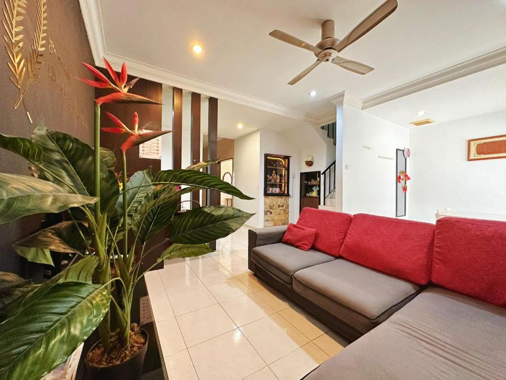 ein Wohnzimmer mit einem Sofa und einer Pflanze in der Unterkunft Stay N rest sweet home 185 in Seremban