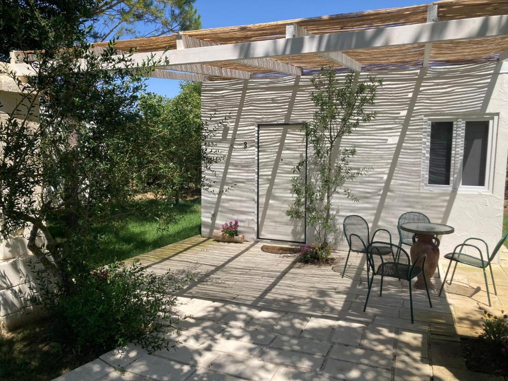 een patio met een tafel en stoelen naast een gebouw bij Agriturismo Tenuta la Monaca in Aradeo