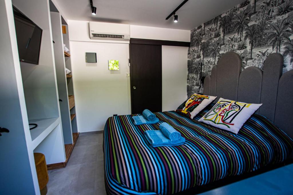 a small bedroom with a bed with a colorful blanket at Appartement de caractère avec Jacuzzi in Fréjus