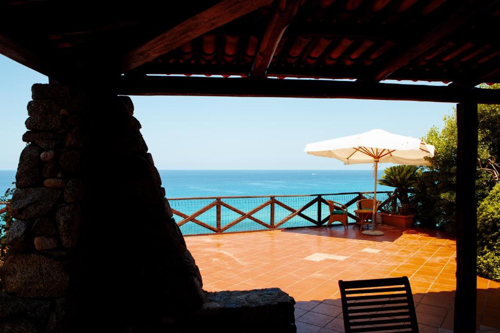 - Patio con sombrilla y vistas al océano en Villa Arianna (Parghelia, Calabria), en Parghelia