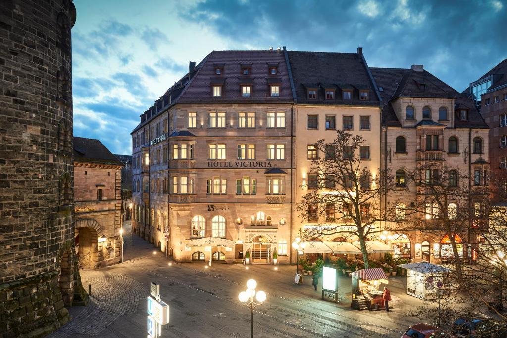 a large building in a city at night at Hotel VICTORIA Nürnberg in Nuremberg