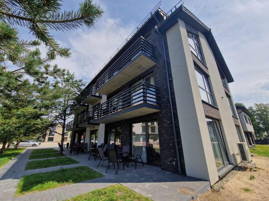 a building with chairs and tables in front of it at 4rest in Palanga