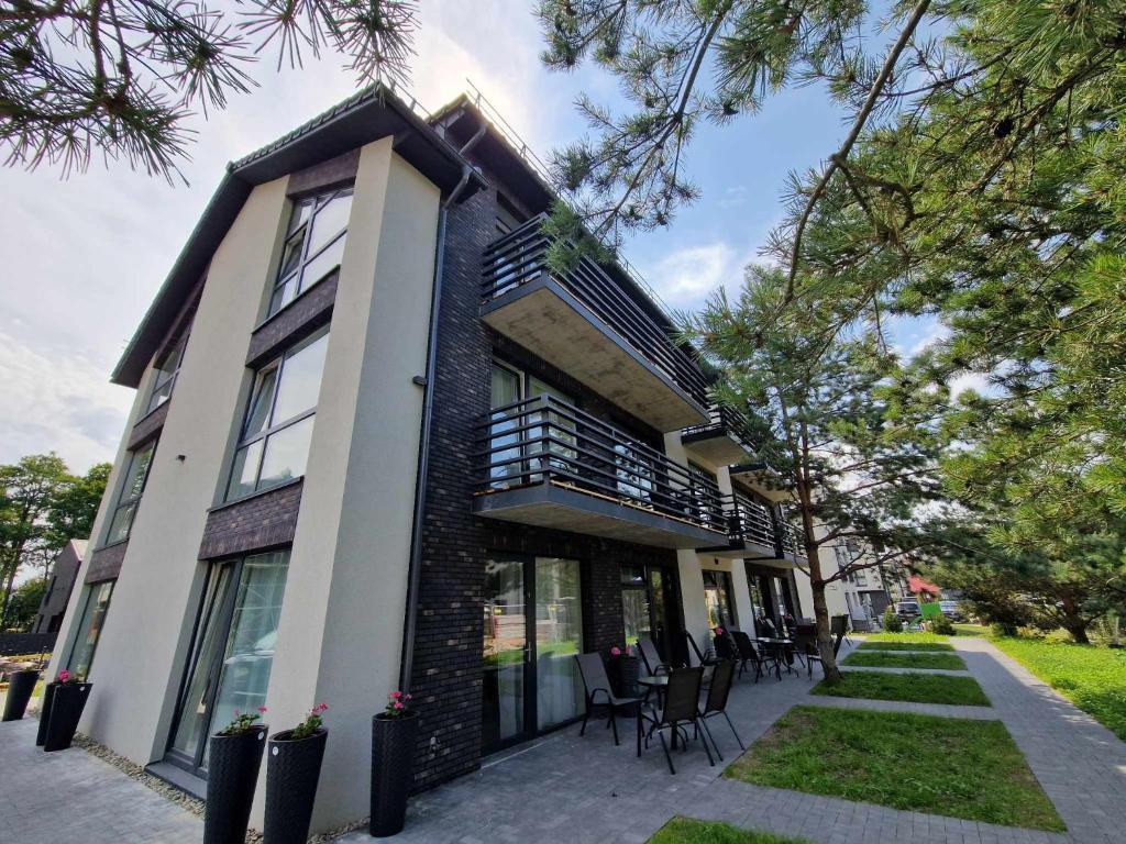 a building with chairs and tables in front of it at 4rest in Palanga