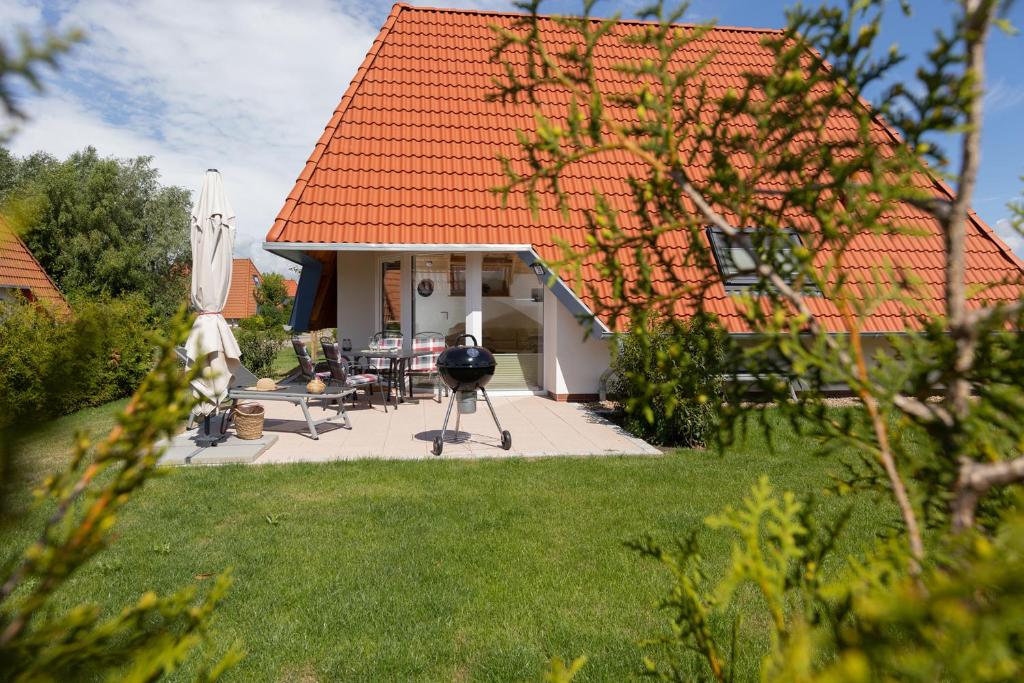 a house with a patio and a table and chairs at MP39 - Strandvogt 2 Komfort in Dorum Neufeld
