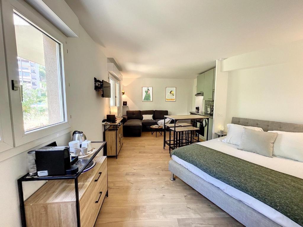 une chambre avec un lit et un salon dans l'établissement Appartement cosy au centre de Cannes, à Cannes