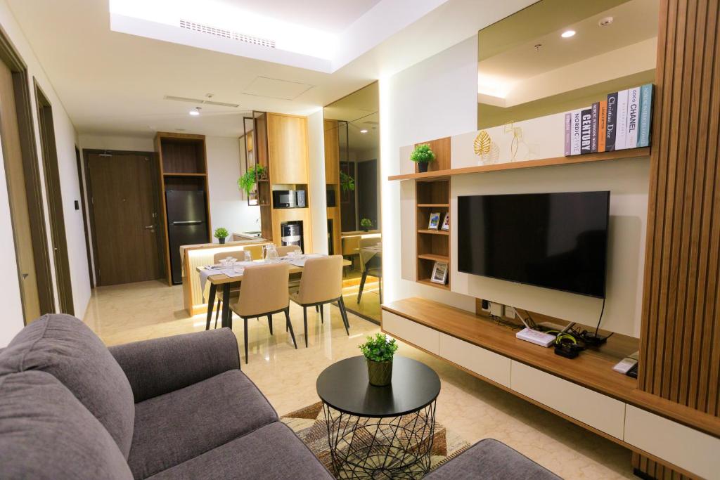 uma sala de estar com um sofá e uma televisão de ecrã plano em Calma 31 Apartment em Makassar