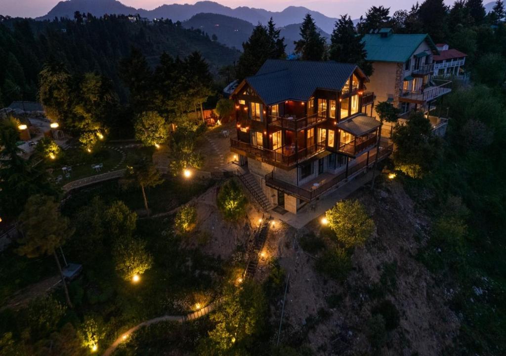 卡纳塔尔Avalon Cottages, Kanatal by Leisure Hotels的夜晚,在空中欣赏大房子的灯光