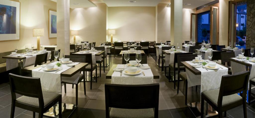 a dining room with tables and chairs in a restaurant at Hotel Playa Calera in Valle Gran Rey