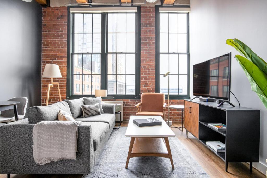 a living room with a couch and a tv at Bright Fort Point Studio w WD in Unit BOS-260 in Boston