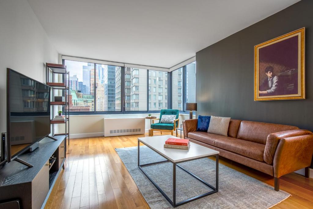 a living room with a couch and a tv at Midtown 1BR w Pool Gym Parking nr Times Sq NYC-378 in New York