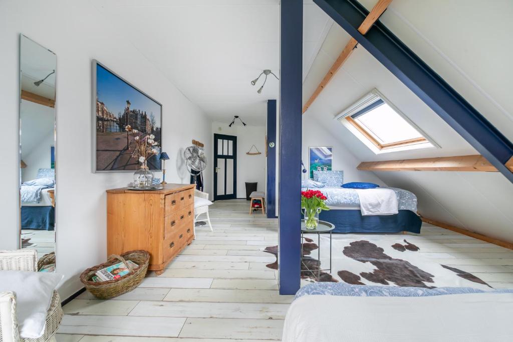 un dormitorio en el ático con una cama y una escalera en Idyllic Farmhouse, en Landsmeer
